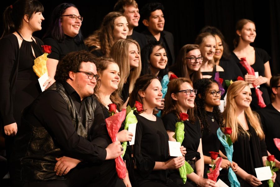 The choir class of 2019 smile with their flowers for a photo at the annual pops concert.