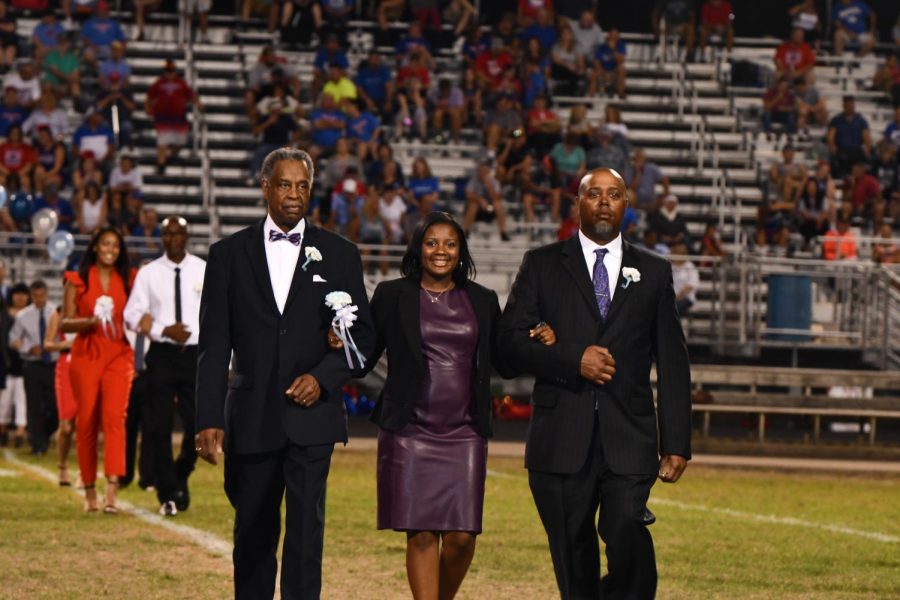 Autumn Jones is escorted down the field by Norman Blankenship and Glenn Jones to represent National Honor Society, during the homecoming game at Boone County high school on Sept. 27. 