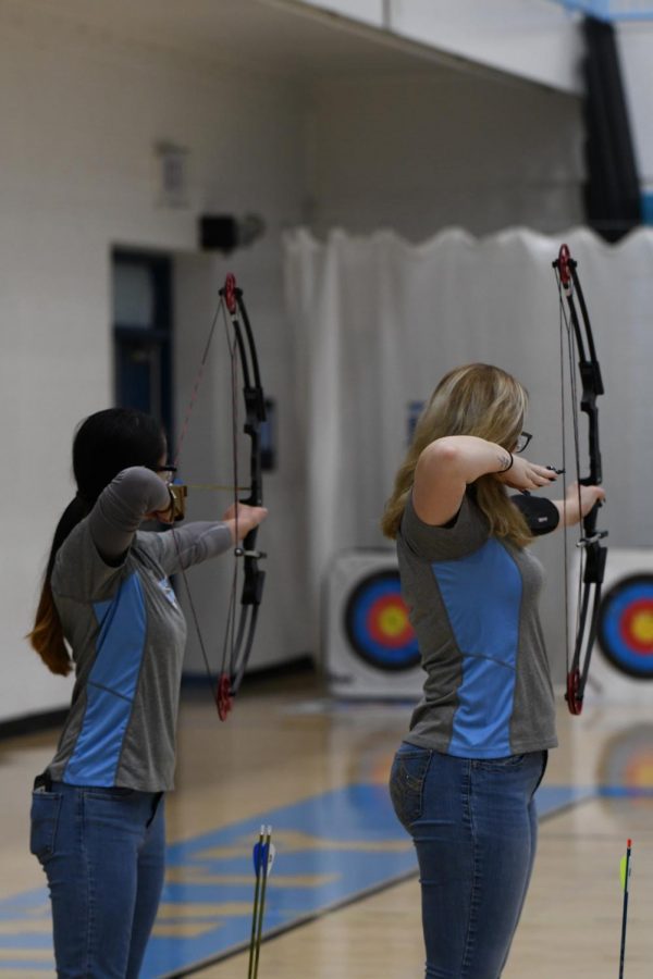 Junior Rosemary Bryant shoots alongside junior Angel Delaney at the archery tournament at Boone County High School on Jan. 11. 