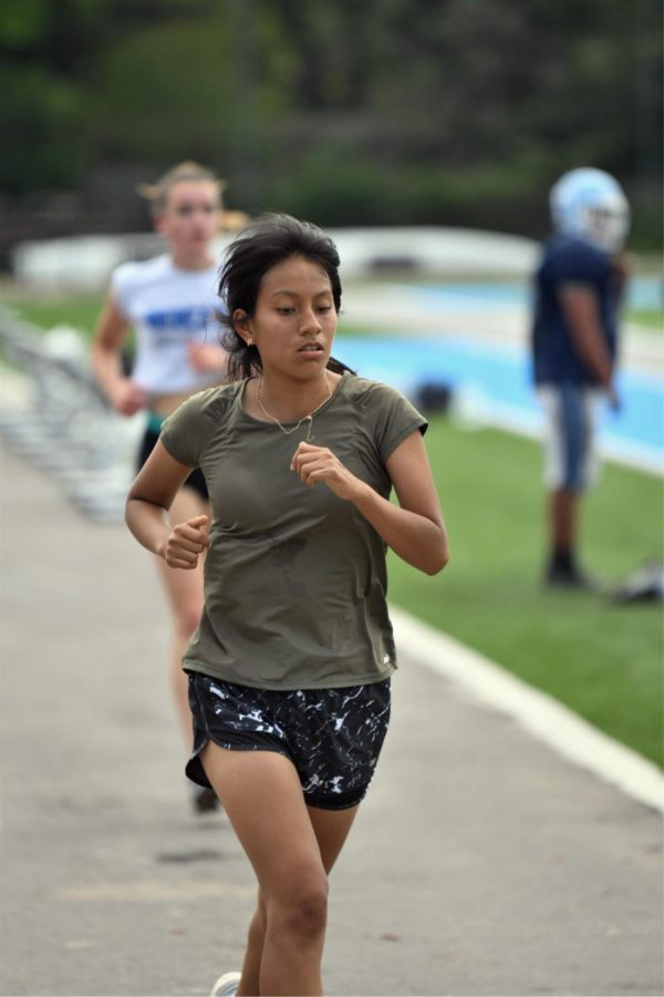 Sophomore+Diana+Zumba+runs++around+the+track+during+practice+on+May+19+while+the+football+team+conducts+spring+practice+on+the+turf+field.++A+track+with+no+markings+or+rubber+surface+is+one+of+several+challenges+faced+by+the+track+programs+in+2021.