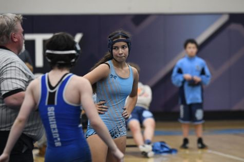 Freshman Rebecca McCray listens to instruction from the referee during the Rebels match against Highlands on Dec. 10. McCray was one of five girls on the wrestling team this  year, but the only girl to also play on the football team.