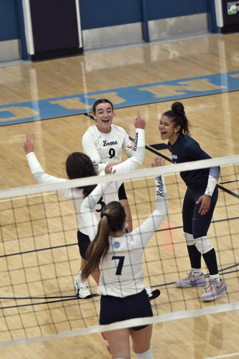 Seniors Marlee Vier (9), Savannah Sauter (3) and Devin Readnour (7) and junior Azaria Sweet (6) celebrate a point during the Lady Rebels match against Newport Central Catholic on Sept. 13.