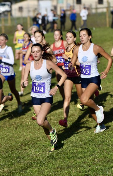 Seniors Avery Fossett (left) and Charlotte Cunningham work to get ahead of the pack at Mason County on Sept. 7.