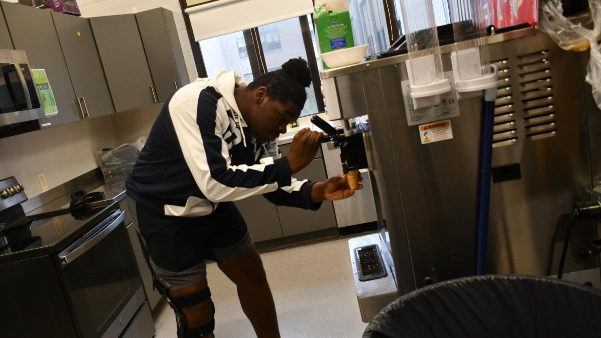 Sophomore Jayden Pointer uses the ice cream machine in room 101 on Nov. 21. Ice cream is being sold to benefit the Family, Career, and Community Leaders of America (FCCLA) and the Family Consumer Science (FCS) classes. 