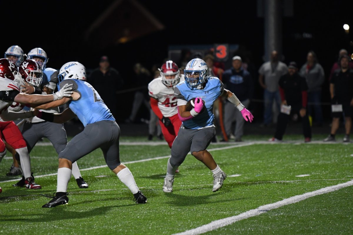 Junior running back Malik Johnson carries the ball while his teammates block the opposing team during the team’s game against Dixie Heights on Oct. 17