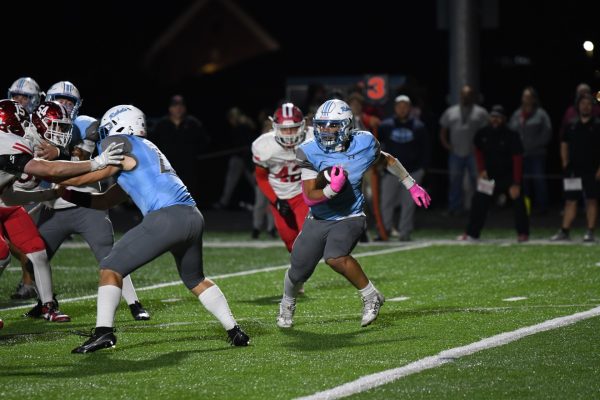 Junior running back Malik Johnson carries the ball while his teammates block the opposing team during the team’s game against Dixie Heights on Oct. 17