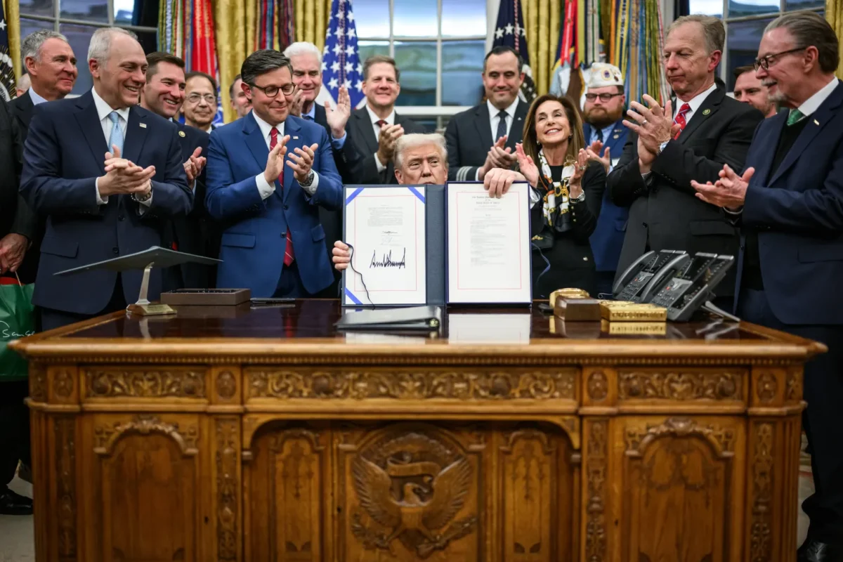 President Donald Trump holds the bill that he signed on Nov. 12, that re-opened the government after 43-days of it being closed, surpassing the previous record of 35-days during Trump's first administration in 2018-2019.