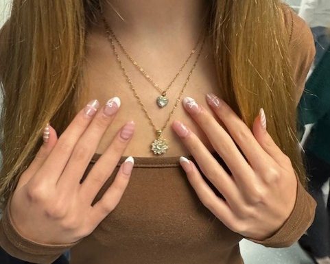 This photo depicts a Boone student who has very fashionable nails and jewelry on that makes her look accessorized and in season.